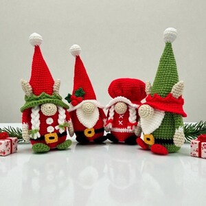 Four festive crochet Christmas gnomes displayed on a white surface with small wrapped gifts and pine branches, including Santa, Mrs. Claus, and two elf gnomes in red, green, and white outfits, handmade amigurumi figures featured for the downloadable PDF crochet pattern.