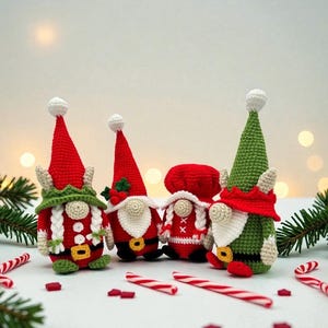 Four crochet Christmas gnomes surrounded by candy canes and pine branches with soft holiday lights in the background, including Santa, Mrs. Claus, and two elf gnomes in red, green, and white outfits, handmade amigurumi figures featured for the downloadable PDF crochet pattern.
