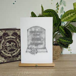 May include: A black and white illustration of a tombstone with the text "Buffy Anne Summers 1981-2001 Beloved Sister Devoted Friend She Saved the World A Lot" on it. There are flowers at the base of the tombstone.