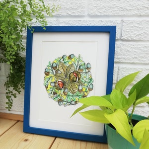 May include: A framed print of a watercolour illustration of a circle of oak leaves and acorns. The leaves are green and brown, and the acorns are light blue and brown. The background is yellow.