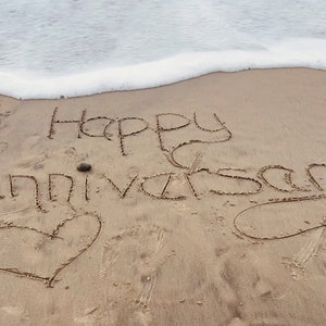 Biglietti da spiaggia personalizzati per l'anniversario scritti nella sabbia
