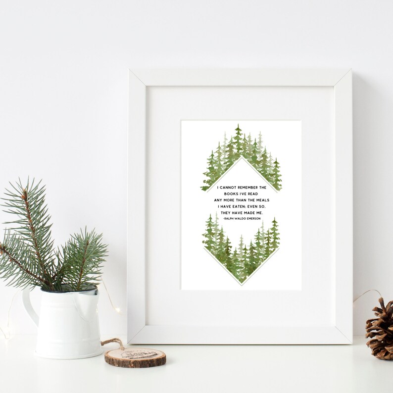 May include: A white framed print with a green watercolour forest design. The quote "I cannot remember the books I've read any more than the meals I have eaten, even so, they have made me." by Ralph Waldo Emerson is printed in black text.
