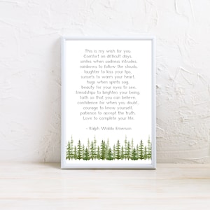 May include: A framed print with a white border features a poem by Ralph Waldo Emerson. The text is in black, set against a white background. A watercolor illustration of green trees is at the bottom of the print.
