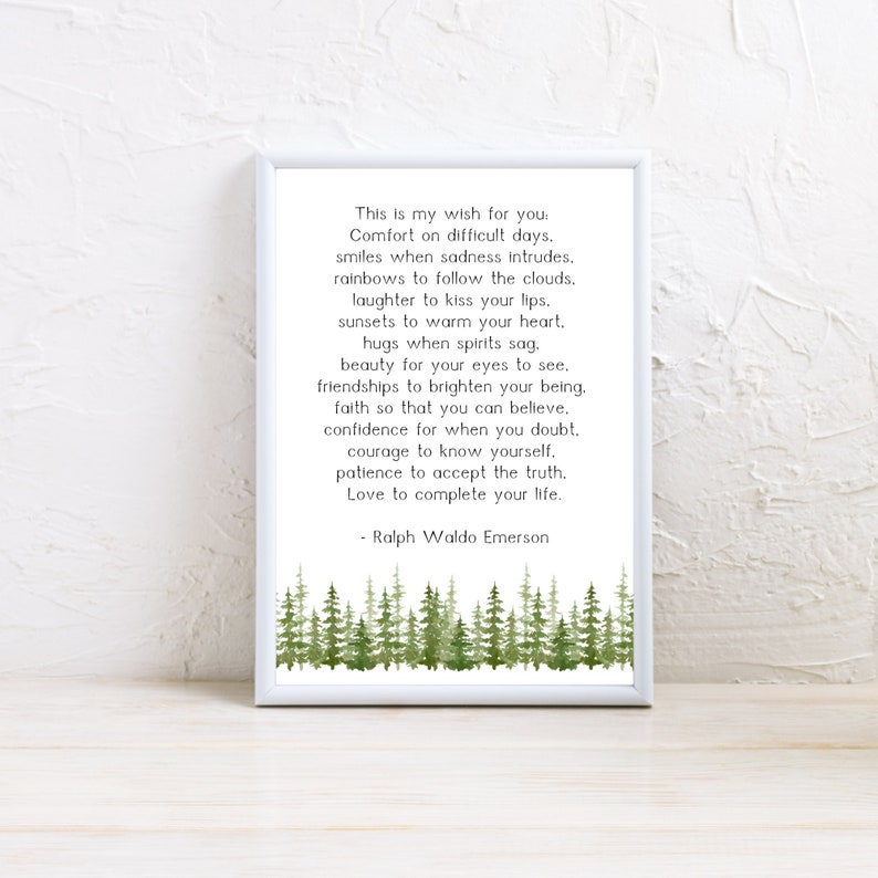 May include: A framed print with a white border features a poem by Ralph Waldo Emerson. The text is in black, set against a white background. A watercolor illustration of green trees is at the bottom of the print.