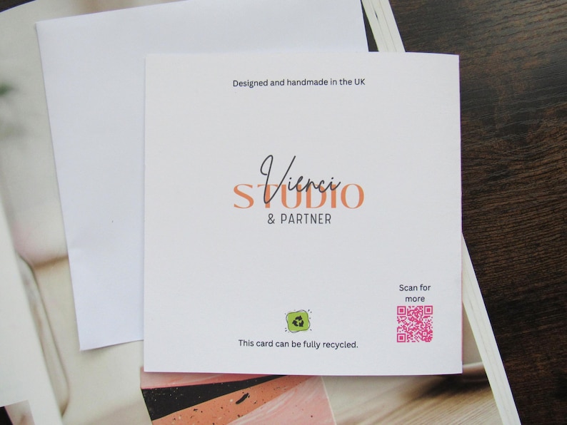 May include: A white card with the text "Vinci STUDIO & PARTNER". The card also includes the text "Designed and handmade in the UK", a QR code, and a recycling symbol. The card is fully recyclable. The card is accompanied by a white envelope.