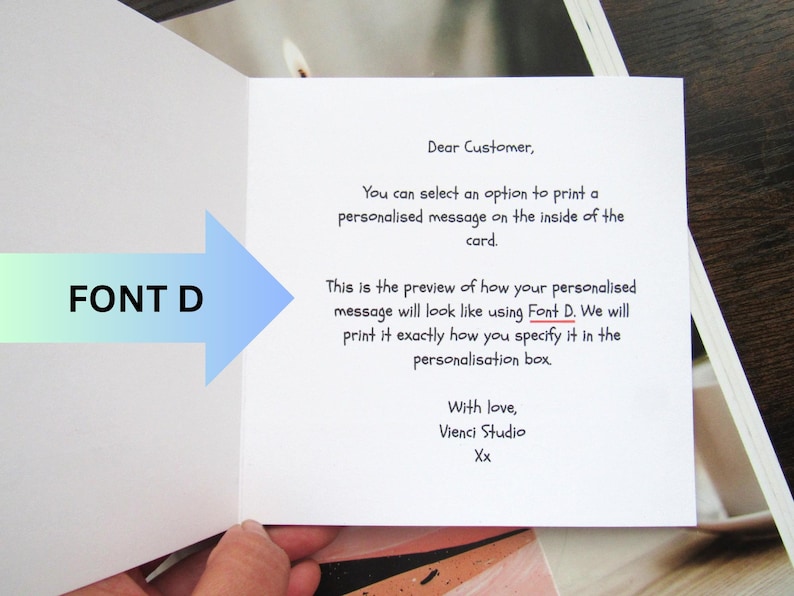 May include: An open greeting card with text. The card's interior features a message preview, with the text "Font D" and an arrow pointing to the text. The card's message is in black font.