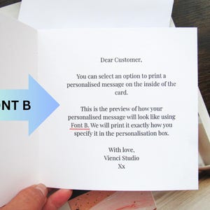 May include: An open greeting card with text. The card's interior displays a message about personalised printing using Font B. A blue and green arrow points to the text "FONT B". The card is held open, revealing the printed message.
