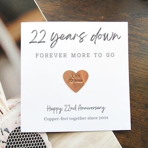 May include: A white card with the text "22 years down, forever more to go" and "Happy 22nd Anniversary." A copper heart with "K & R 22 years" is affixed to the card. The phrase "Copper-fect together since 2004" is also printed on the card.
