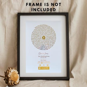 Könnte beinhalten: Gerahmter Druck mit weißem Hintergrund, der Songtexte in einem kreisförmigen Muster anzeigt. Der Text "FRAME IS NOT INCLUDED" befindet sich oben. Der Druck enthält die Namen "Olivia & James", "Our Wedding Song" und eine Musikplayer-Grafik.