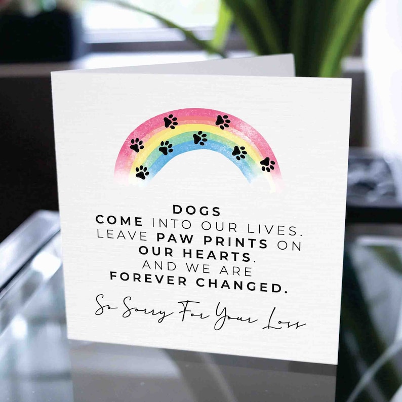 Puede incluir: Tarjeta de condolencia blanca con un arco&iacute;ris y huellas de patas. El texto dice: "LOS PERROS ENTRAN EN NUESTRAS VIDAS. DEJAN HUELLAS DE PATAS EN NUESTROS CORAZONES. Y CAMBIAMOS PARA SIEMPRE. Lo siento mucho por tu p&eacute;rdida."