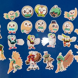 May include: A collection of 22 colorful stickers featuring various Pokemon characters, including Rowlet, Dartrix, and Decidueye. The stickers are all different sizes and shapes, and they are all printed on a white background.