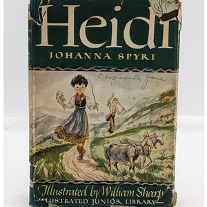 May include: A vintage book cover for "Heidi" by Johanna Spyri, illustrated by William Sharp. The cover features a green background with the title in white lettering. The illustration depicts a young girl in a traditional dress walking on a path with goats in the background. The book is part of the Illustrated Junior Library series.