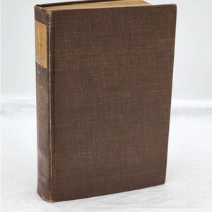 May include: A brown hardcover book with a spine label. The book is on a white surface.