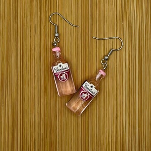 Mini Gordons Pink Gin bottle novelty earrings.