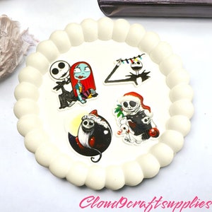 May include: A cream-coloured, scalloped-edge tray displays four character stickers from The Nightmare Before Christmas. The stickers feature Jack Skellington and Sally, Jack with Christmas lights, a Jack-O-Lantern, and Jack with a Santa hat. The text "Cloud9craftsupplies" is visible.