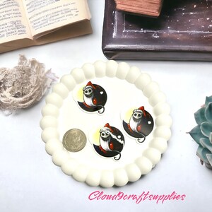 May include: A cream-coloured, scalloped-edge tray holds three stickers featuring a cartoon character in a Santa hat against a black and yellow background. A coin and a succulent plant are also visible. The text "Cloud9craftsupplies" is in the bottom right corner.