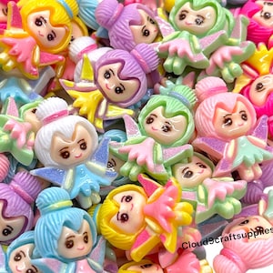 May include: A collection of colorful fairy-shaped embellishments in various shades of pink, yellow, green, blue, and purple. Each fairy has a smiling face and wings, perfect for crafting projects. The text "Cloud9craftsupplies" is visible.