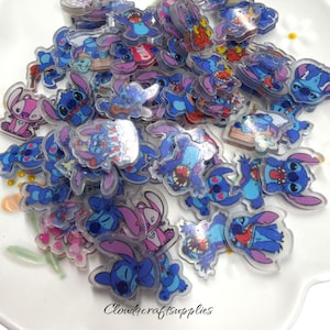 May include: A collection of small, flat, acrylic charms featuring various colorful illustrations of the blue alien character Stitch and the pink alien character Angel in different poses, expressions, and outfits, with the text Cloudcraftsupplies.