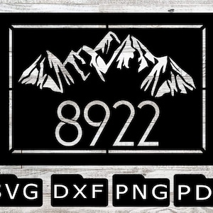 May include: Black and white silhouette of mountain peaks with the house number 8922 in a white font. The design is framed in a black square with a white border. The image is on a white wood background with the file types SVG, DXF, PNG, and PDF listed below.