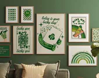 May include: A collection of green and white framed prints with Irish-themed designs, including a horseshoe, a clover, a rainbow, and a frog. The prints are hanging on a green wall above a green sofa with two pillows.