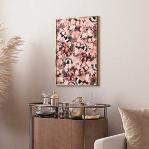 May include: A framed print of a pink and white disco ball pattern. The print is in a gold frame and is hanging on a white wall.