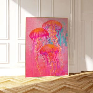May include: A digital art print featuring three pink and orange jellyfish with long tentacles against a pink and blue background.