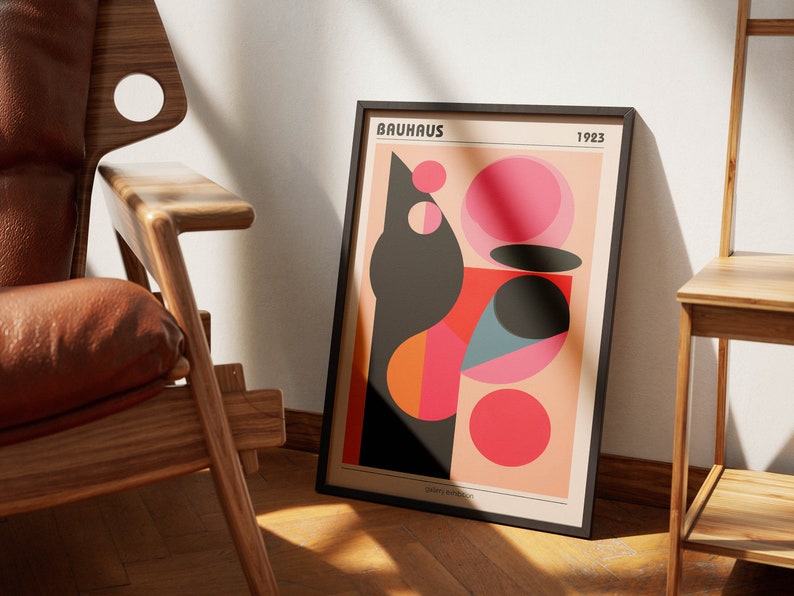 May include: A framed poster featuring a geometric design in black, red, orange, pink, and blue. The poster has the text "BAUHAUS 1923" at the top.