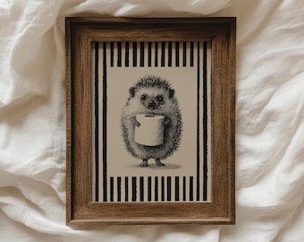 May include: A framed print featuring a detailed illustration of a hedgehog holding a roll of toilet paper. The artwork is in black and white, set against a striped background, and encased in a brown wooden frame. The print is a whimsical piece of home decor.