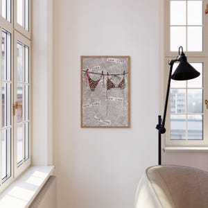 May include: A framed print of a leopard print bikini hanging on a clothesline with the words "New York" printed on a newspaper background.