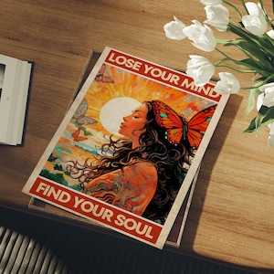 May include: A colorful poster with a woman with long flowing hair and a butterfly on her head. The poster has the text "Lose Your Mind Find Your Soul" in a vintage style font.