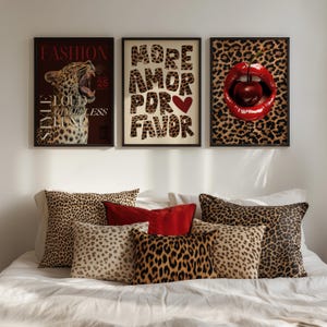 May include: Three framed prints with a leopard print background. The left print features a magazine cover with the text "FASHION" and a roaring leopard. The middle print features the text "MORE AMOR POR FAVOR" in red and white letters. The right print features a red, cherry-filled mouth on a leopard print background.