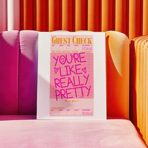 May include: A pink and white guest check with the text "YOU'RE LIKE REALLY PRETTY" written in pink. The check has a grid pattern and the check number is 823645.