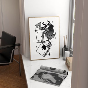 May include: A black and white illustration of a lighter with flames coming out of it. The lighter is on top of two playing cards, an ace of spades and a seven of diamonds. The illustration is surrounded by stars.