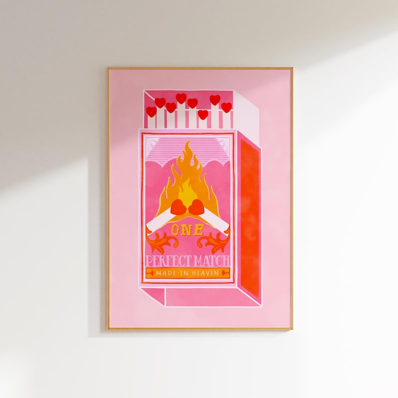 May include: A pink and orange illustration of a matchbox with the text "One Perfect Match Made In Heaven". The matchbox is open and the matches are on fire. The matches are shaped like hearts.