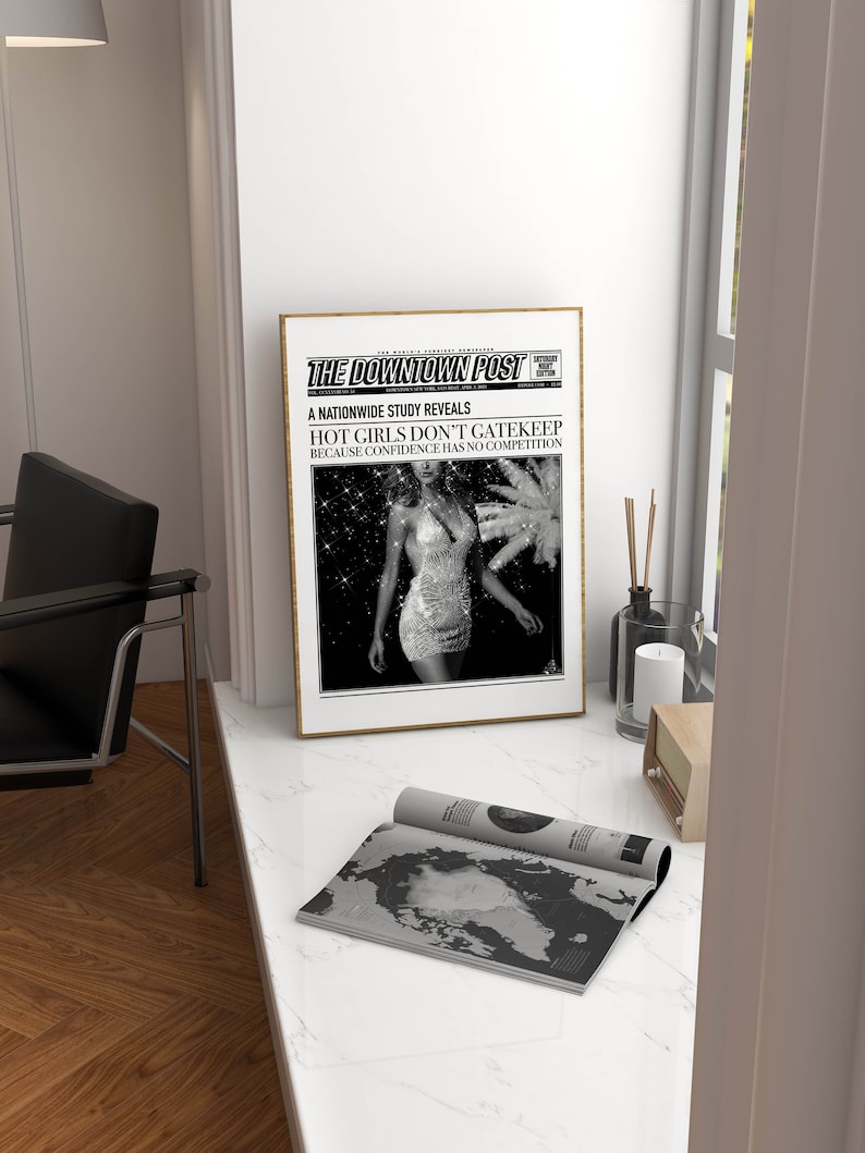 May include: A framed poster titled The Downtown Post featuring a black and white photograph of a person in a sequined dress. The headline reads A NATIONWIDE STUDY REVEALS HOT GIRLS DON'T GATEKEEP BECAUSE CONFIDENCE HAS NO COMPETITION in bold text.