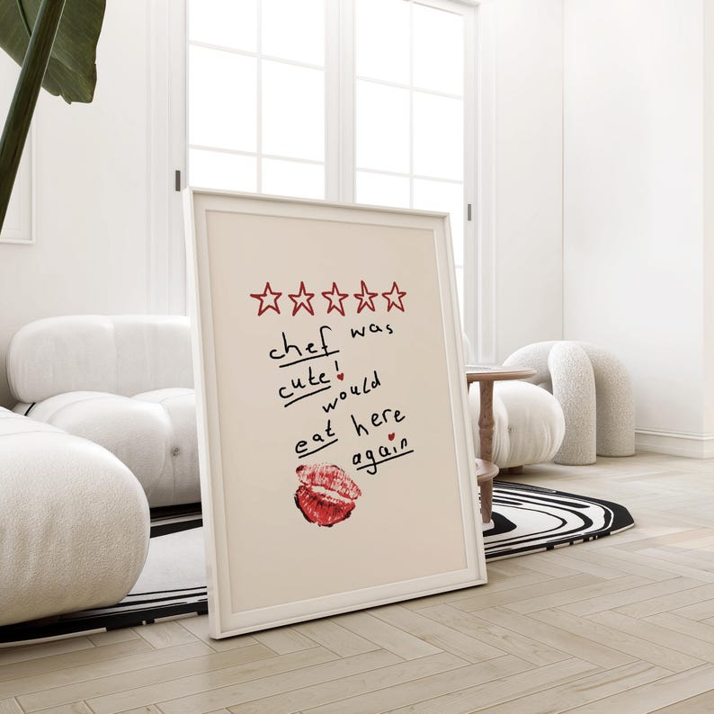 Op de afbeelding: Een ingelijst afdruk met een vijfsterrenbeoordeling en de tekst "kok was schattig! zou hier weer eten" met een rood hart en een rode lippenstiftkus.