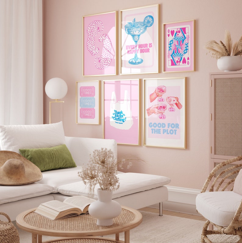 Puede incluir: Un conjunto de seis impresiones enmarcadas en rosa y azul con varios dise&ntilde;os, que incluyen una copa de c&oacute;ctel, una carta de juego, una bolsa de compras y un boleto. Las impresiones est&aacute;n colgadas en una pared rosa en un ambiente de sala de estar.