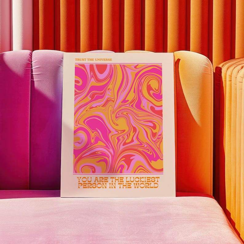 Peut inclure: Une affiche blanche avec un motif abstrait en spirale rose, orange et jaune. Le texte "Trust the Universe" est en haut et "You are the luckiest person in the world" est en bas.