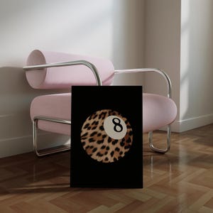 May include: A black and white print of a leopard print billiard ball with the number 8 on it. The print is on a black background.