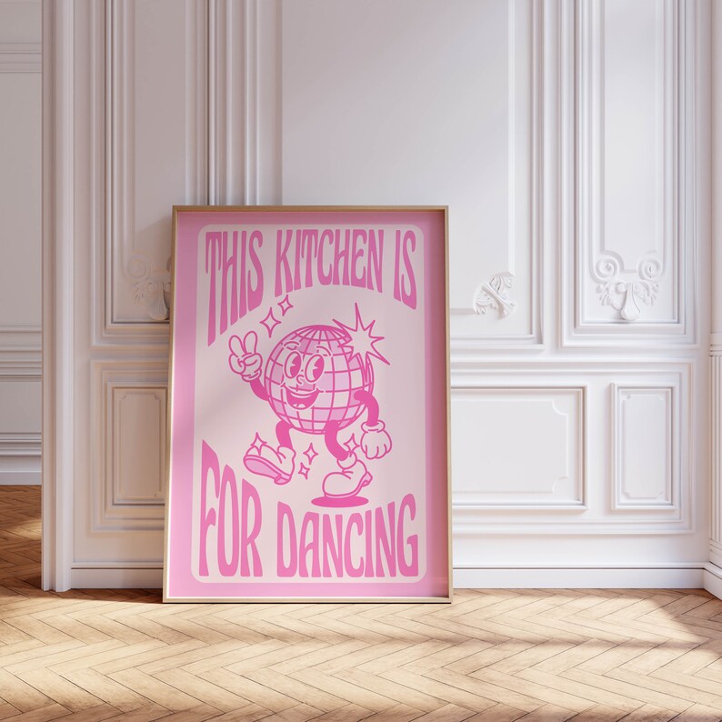 May include: Pink poster with a disco ball character dancing and the text "This kitchen is for dancing".