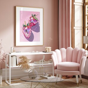 May include: A framed print of two pink disco ball strawberries on a pink background.