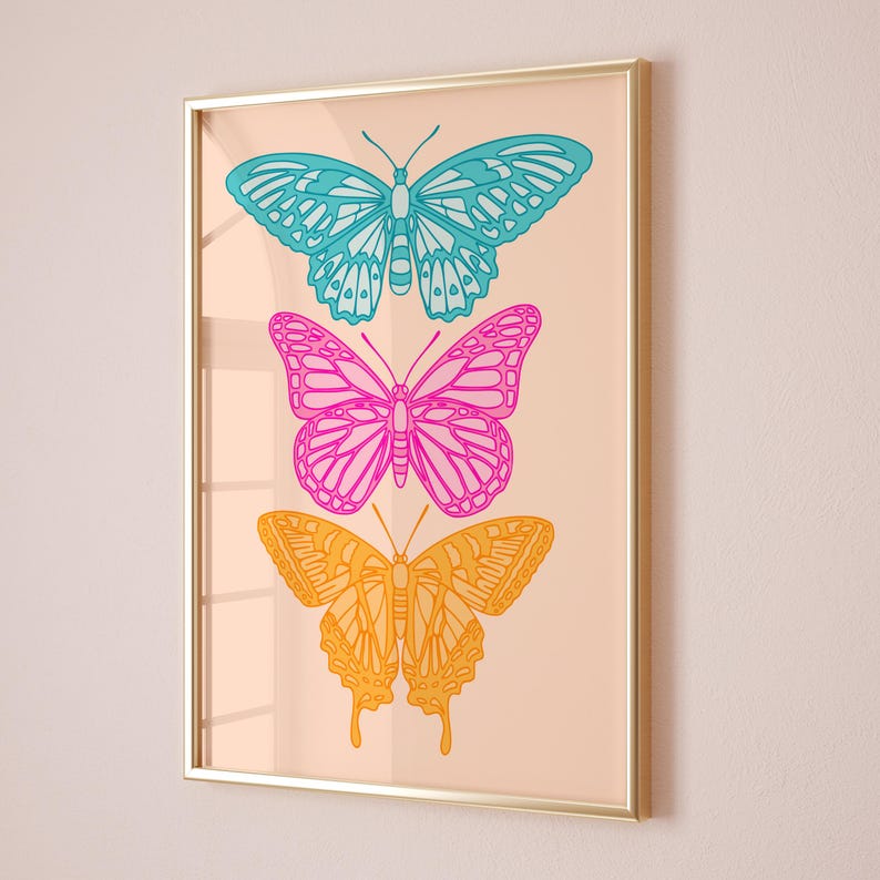 Pode incluir: Uma impress&atilde;o emoldurada com tr&ecirc;s borboletas dispostas verticalmente. A borboleta superior &eacute; azul, a borboleta do meio &eacute; rosa e a borboleta inferior &eacute; amarela. As borboletas s&atilde;o delineadas em preto e t&ecirc;m um fundo branco.