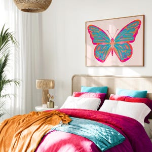 May include: A bedroom with a white bed, a pink duvet, a teal throw blanket, and a large framed print of a pink and blue butterfly on the wall.