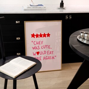 May include: A framed print with a pink background and white text that reads "Chef was cute, would eat here again."  Five red stars are above the text.
