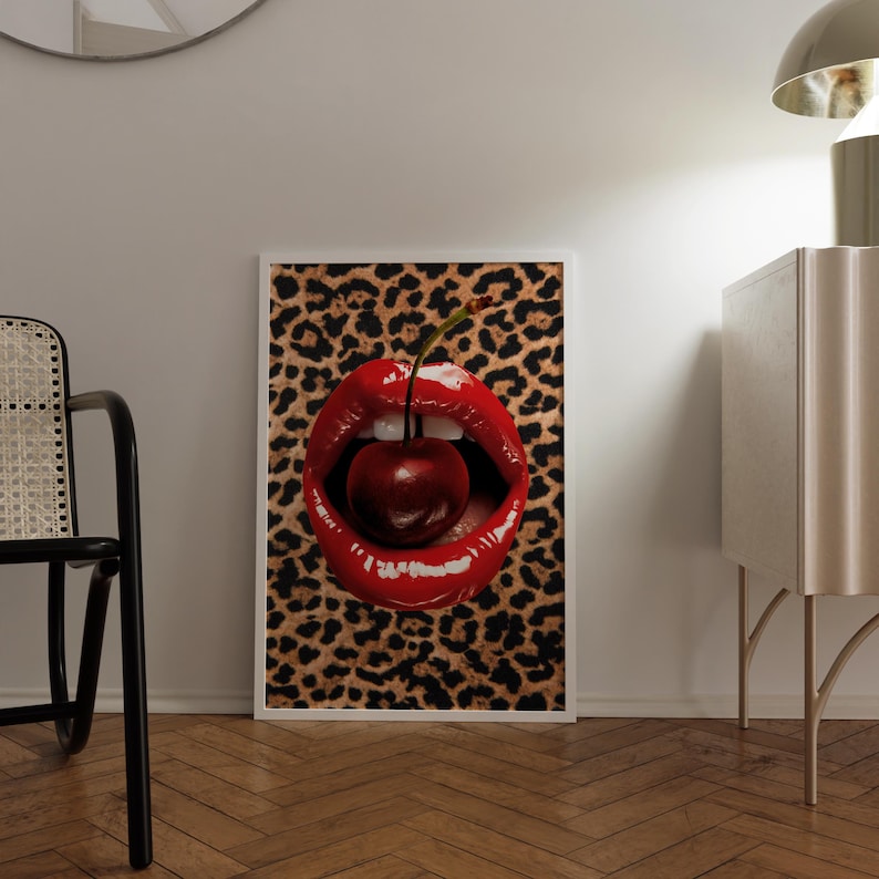 May include: A close-up of a pair of red lips with a cherry inside. The lips are glossy and the cherry is red with a green stem. The background is a leopard print.
