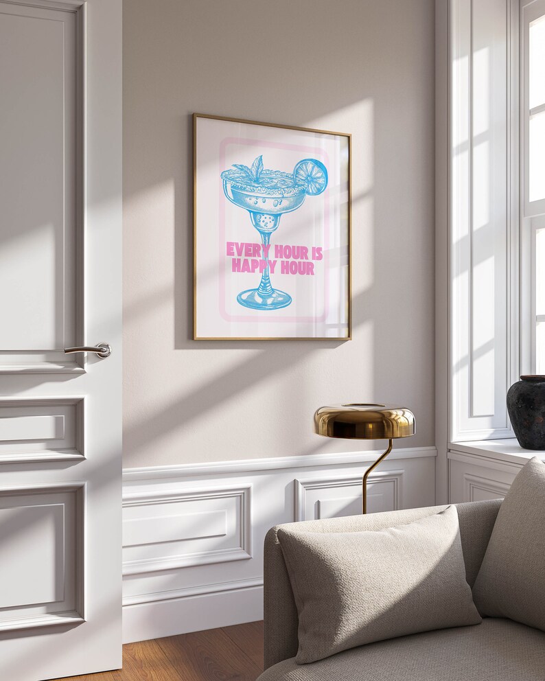 Puede incluir: Una impresi&oacute;n enmarcada con una ilustraci&oacute;n azul de una copa de margarita con una rodaja de lima y el texto "Every hour is happy hour" en rosa.