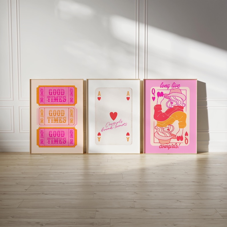 May include: Three framed prints with a pink and orange color scheme. The left print features the text "Good Times" repeated three times. The middle print features a red heart with the text "Cowgirls break hearts". The right print features a pink background with a woman in a cowboy hat and the text "long live cowgirls!"