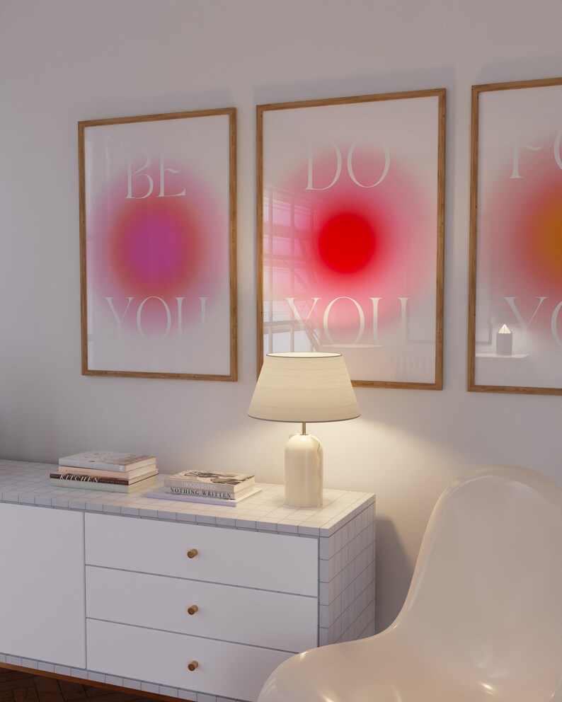 Peut inclure: Trois impressions encadr&eacute;es avec un fond d&eacute;grad&eacute; et du texte blanc. Le texte sur les impressions est "Be You", "Do You" et "For You". Les impressions sont accroch&eacute;es &agrave; un mur blanc au-dessus d'une commode blanche avec une lampe et une chaise blanche.