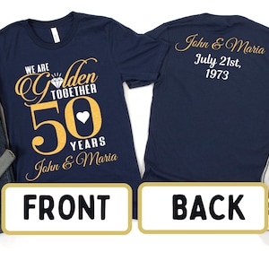 May include: Navy blue t-shirt with gold text that reads "We are Golden Together 50 Years John & Maria". The back of the shirt has gold text that reads "John & Maria July 21st, 1973".