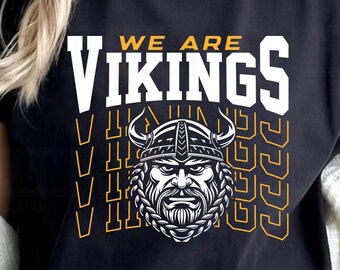 Może przedstawiać: Czarny t-shirt z napisem "WE ARE VIKINGS" w kolorze białym i żółtym. Koszulka przedstawia grafikę wojownika wikingów z hełmem i brodą. Projekt jest wyśrodkowany na przodzie koszulki.